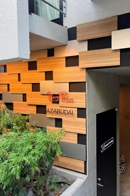 a building with a sign on the side of it at Ken's Place Azabudai in Tokyo
