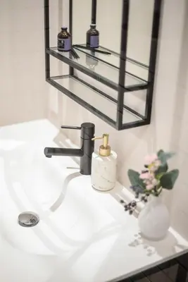 a bathroom sink with a soap dispenser and a mirror at Ken's Place Azabudai in Tokyo