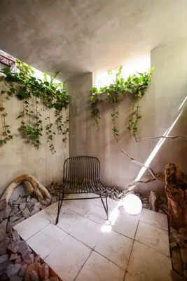 a chair in a room with plants on the wall at Ken's Place Azabudai in Tokyo
