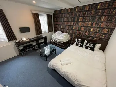 a bedroom with a bed and a desk in it at Exsasion Sugamo in Tokyo