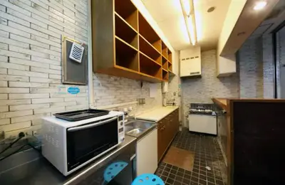 a small kitchen with a sink and a microwave at Exsasion Sugamo in Tokyo