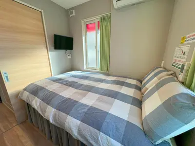 a small bedroom with a bed and a window at SHINJUKU WARM HOUSE in Tokyo