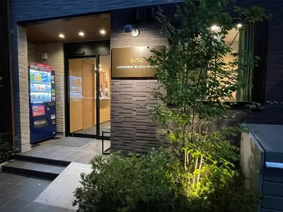 a building with a sign on the side of it at SHINJUKU WARM HOUSE in Tokyo