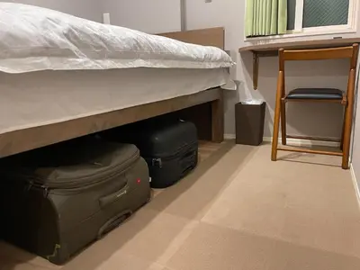 a room with a bed and luggage under a bed at SHINJUKU WARM HOUSE in Tokyo