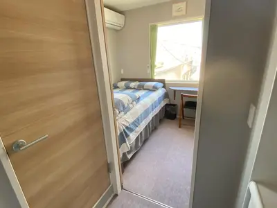 a small bedroom with a bed and a window at SHINJUKU WARM HOUSE in Tokyo