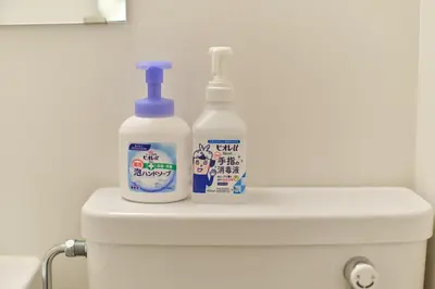 two bottles of cleaner sitting on the back of a toilet at TORA HOTEL Tokyo Ueno \u5bc5\u30db\u30c6\u30eb \u4e0a\u91ce B in Tokyo