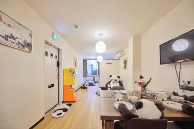 a living room with stuffed pandas sitting on the floor at TORA HOTEL Tokyo Ueno \u5bc5\u30db\u30c6\u30eb \u4e0a\u91ce B in Tokyo
