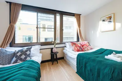 a living room with two beds and a window at TORA HOTEL Tokyo Ueno \u5bc5\u30db\u30c6\u30eb \u4e0a\u91ce C in Tokyo