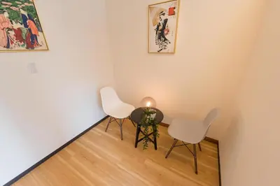 a room with two chairs and a table with a candle at TORA HOTEL Tokyo Ueno \u5bc5\u30db\u30c6\u30eb \u4e0a\u91ce D in Tokyo