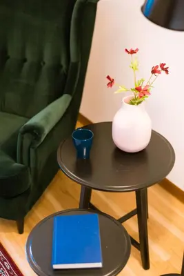a table with a vase with flowers and a book at TORA HOTEL Tokyo Ueno \u5bc5\u30db\u30c6\u30eb \u4e0a\u91ce D in Tokyo