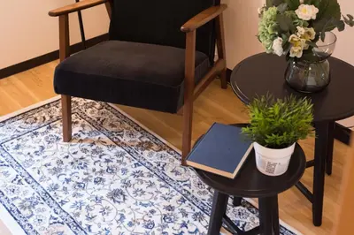 a black chair sitting next to a table with a book at TORA HOTEL Tokyo Ueno \u5bc5\u30db\u30c6\u30eb \u4e0a\u91ce D in Tokyo