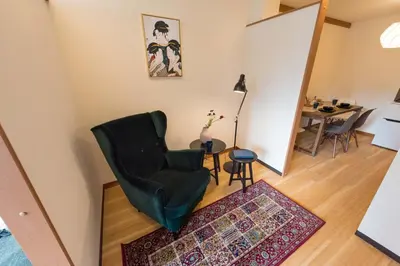 a living room with a chair and a table at TORA HOTEL Tokyo Ueno \u5bc5\u30db\u30c6\u30eb \u4e0a\u91ce D in Tokyo