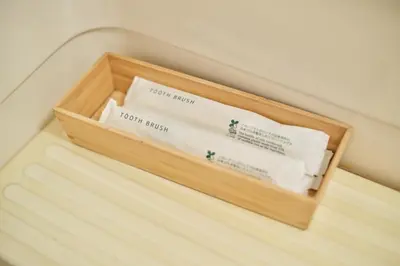 a wooden box filled with towels on a bed at TORA HOTEL Tokyo Ueno \u5bc5\u30db\u30c6\u30eb \u4e0a\u91ce D in Tokyo