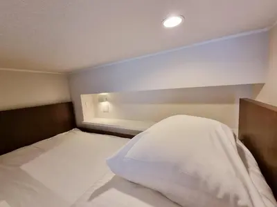 a bedroom with a bed with a white pillow at PRISM INN Asakusa in Tokyo