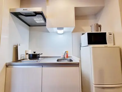 a small kitchen with a microwave and a refrigerator at PRISM INN Asakusa in Tokyo