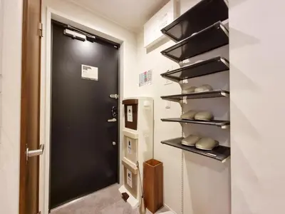 a hallway with a black door and a refrigerator at PRISM INN Asakusa in Tokyo