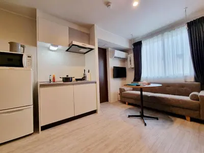 a kitchen with a couch and a table in a room at PRISM INN Asakusa in Tokyo
