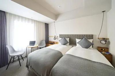 a hotel room with two beds and a desk at Hotel Resol Stay Akihabara in Tokyo