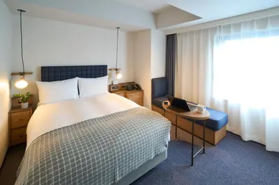 a hotel room with a bed and a laptop on a table at Hotel Resol Stay Akihabara in Tokyo