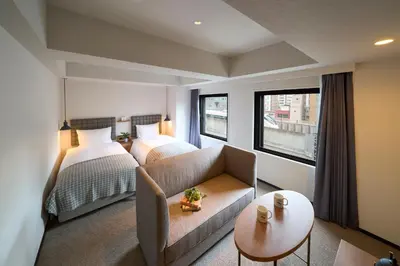 a hotel room with two beds and a couch at Hotel Resol Stay Akihabara in Tokyo