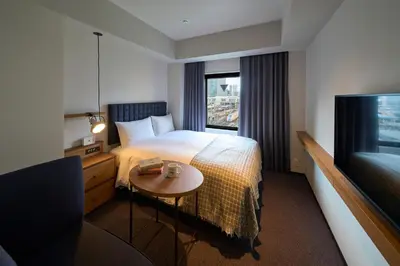 a hotel room with a bed and a table and a television at Hotel Resol Stay Akihabara in Tokyo