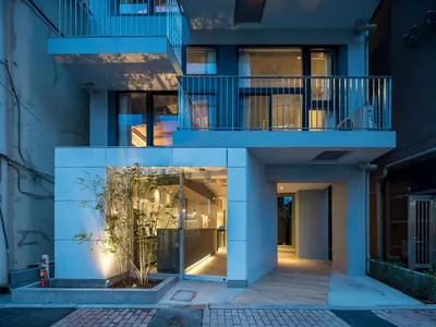 a blue building with a balcony and a plant at dots. tokyo in Tokyo