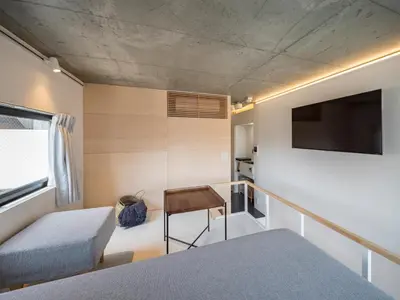 a bedroom with a bed and a desk and a tv at dots. tokyo in Tokyo