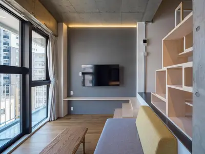 a living room with a couch and a tv on a wall at dots. tokyo in Tokyo