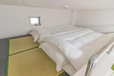 a white bed in a room with a window at japan house Ikebukuro in Tokyo