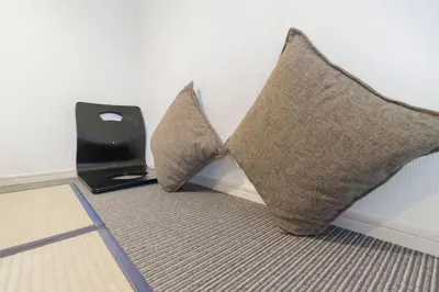 two pillows sitting on a floor next to a speaker at japan house Ikebukuro in Tokyo