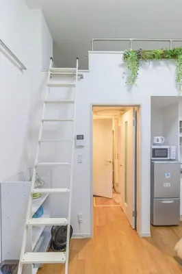 a bunk bed in a room with a ladder at japan house Ikebukuro in Tokyo