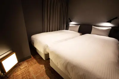 two beds in a hotel room with white sheets at LOF HOTEL Shimbashi in Tokyo