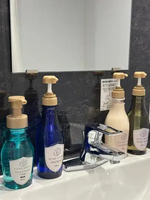 three bottles of soap on a bathroom sink at LOF HOTEL Shimbashi in Tokyo