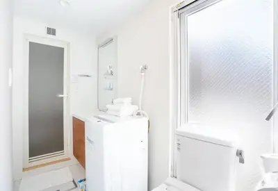 a white bathroom with a toilet and a sink at japan house ebisu in Tokyo