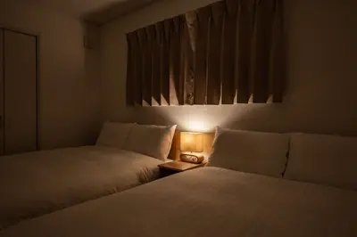 two beds in a room with a light between them at Noah Ikebukuro - Vacation STAY 11164 in Tokyo