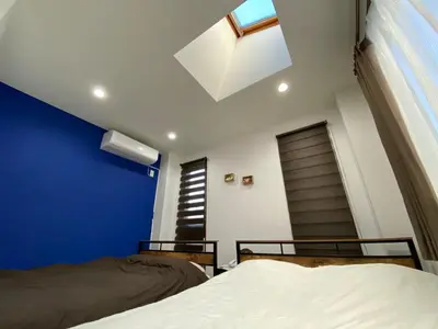 a bedroom with two beds and a blue wall at Wonderful stay TOKYO - Vacation STAY 30862v in Tokyo