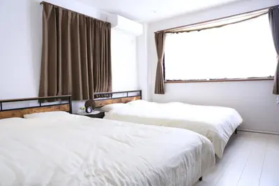 two beds in a room with a window at Wonderful stay TOKYO - Vacation STAY 30862v in Tokyo