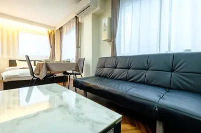 a living room with a couch and a table at Serendipity Kinshicho - 7 mins to JR Station - Near Skytree & Foodie hub in Tokyo