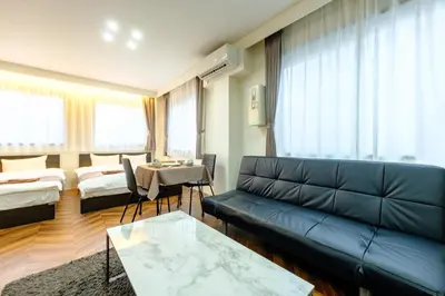 a living room with a couch and a table at Serendipity Kinshicho - 7 mins to JR Station - Near Skytree & Foodie hub in Tokyo