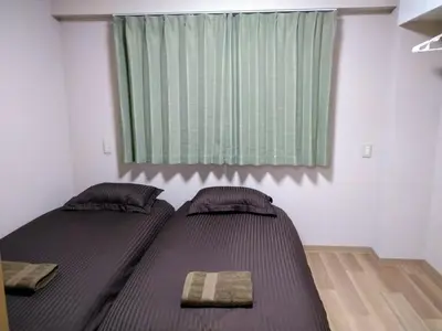 two beds in a small room with a window at Hitoyado Ryokan Higashiueno - Vacation STAY 35819v in Tokyo
