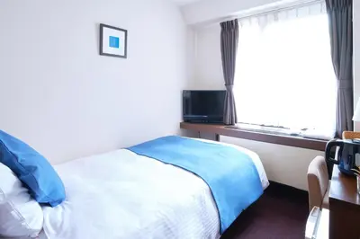 a hotel room with a bed and a window at Pod Select Hotel Shinjuku in Tokyo
