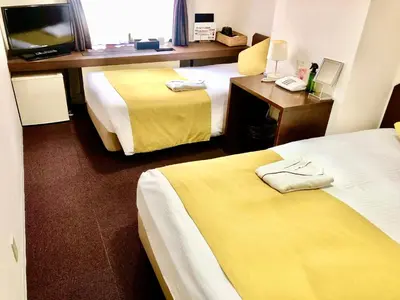 a hotel room with two beds and a television at Pod Select Hotel Shinjuku in Tokyo