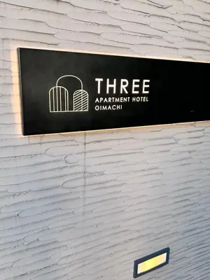 a sign for a three apartment hotel on a wall at THREE in Tokyo