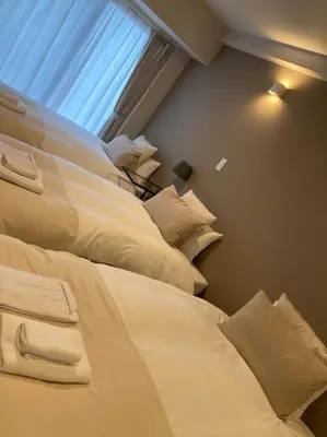 two beds in a room with a window at THREE in Tokyo