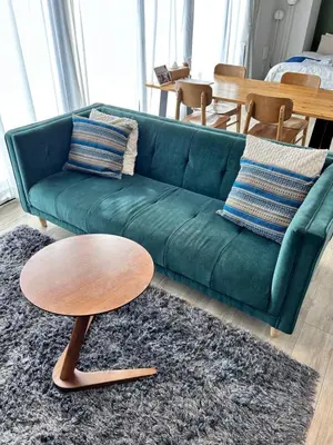 a green couch with a wooden coffee table in a living room at THREE in Tokyo