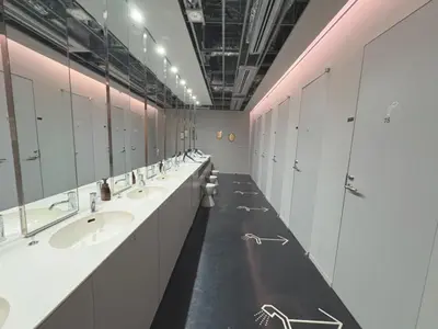 a bathroom with a row of sinks and mirrors at Rembrandt Cabin Shinjuku Shin-Okubo in Tokyo