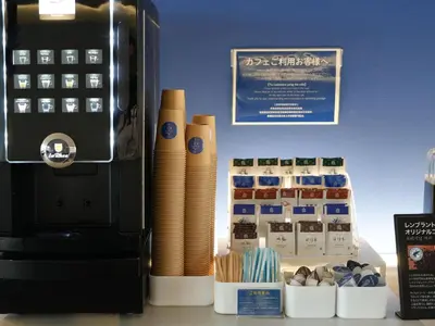 a office with a coffee machine next to a box ofaments at Rembrandt Cabin Shinjuku Shin-Okubo in Tokyo