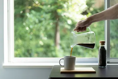 a person pouring coffee into a cup on a table at Shibuya-ku - House - Vacation STAY 11243 in Tokyo