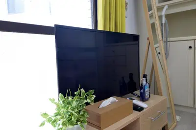 a large flat screen tv sitting on a wooden stand at Oji Natural Cosy House in Tokyo