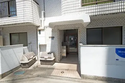 a building with two benches in front of a door at Oji Natural Cosy House in Tokyo